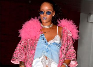 Rihanna has been out of the spotlight for months, enjoying some off time in London, but she is back and she is looking better than ever. She stunned in a double denim look as she headed to an office building in NYC while preparing for the Met Gala. She showcases a piece from her upcoming Savage x Fenty Lingerie line , a white lace night shirt, under what appeared to be a Denim skirt worn as a top. She topped it off with a pink coat.