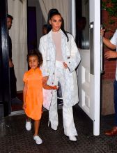Kim Kardashian NYC Hotel with daughter North West on Saturday night. They headed to NBC Studios to watch Dad, Kanye West, perform on SNL. North wore a custom Yeezy dress in Neon Orange, while Kim wore a white python trench coat and matching pants combo.