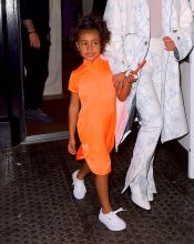 Kim Kardashian NYC Hotel with daughter North West on Saturday night. They headed to NBC Studios to watch Dad, Kanye West, perform on SNL. North wore a custom Yeezy dress in Neon Orange, while Kim wore a white python trench coat and matching pants combo.
