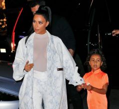 Kim Kardashian NYC Hotel with daughter North West on Saturday night. They headed to NBC Studios to watch Dad, Kanye West, perform on SNL. North wore a custom Yeezy dress in Neon Orange, while Kim wore a white python trench coat and matching pants combo.