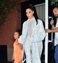 Kim Kardashian NYC Hotel with daughter North West on Saturday night. They headed to NBC Studios to watch Dad, Kanye West, perform on SNL. North wore a custom Yeezy dress in Neon Orange, while Kim wore a white python trench coat and matching pants combo.