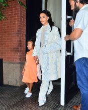 Kim Kardashian NYC Hotel with daughter North West on Saturday night. They headed to NBC Studios to watch Dad, Kanye West, perform on SNL. North wore a custom Yeezy dress in Neon Orange, while Kim wore a white python trench coat and matching pants combo.