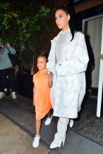Kim Kardashian NYC Hotel with daughter North West on Saturday night. They headed to NBC Studios to watch Dad, Kanye West, perform on SNL. North wore a custom Yeezy dress in Neon Orange, while Kim wore a white python trench coat and matching pants combo.