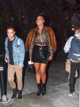 EJ Johnson wearing Fendi fur jacket and blouse with patent leather mini skirt and booties in Los Angeles, CA.