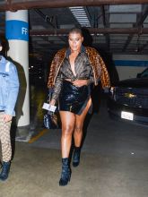 EJ Johnson wearing Fendi fur jacket and blouse with patent leather mini skirt and booties in Los Angeles, CA.