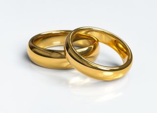 High Angle View Of Wedding Rings Against White Background