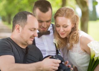Wedding photographer showing the photos to the couple