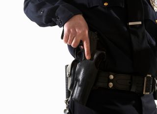 Male police officer reaching for his holster