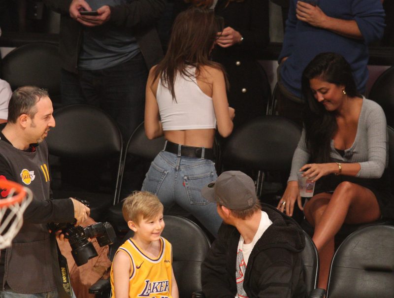 Model Emily Ratajkowski manages to get a dad who was sitting in front of her checking out her buns as she shows of her spectacular assets as she poses courtside while attending the Los Angeles Lakers Vs The Minnesota Timberwolves game at The Staples Center in Los Angeles, Ca