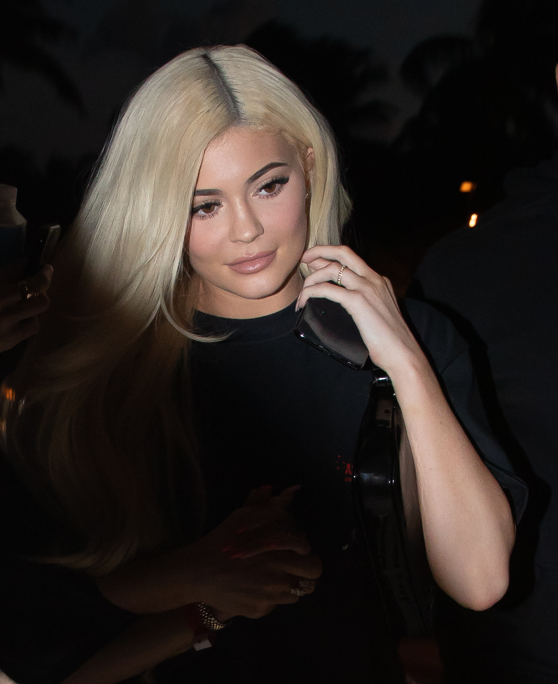 Kylie Jenner leaves Mr Chow restaurant at the W South Beach hotel in Miami with her BFF Jordyn Woods. Jenner wore white long boots and a Travis Scott tour t-shirt as she headed to his Sunday night tour date. She also sported a diamond ring on her wedding finger amid rumors of an engagement to Scott.