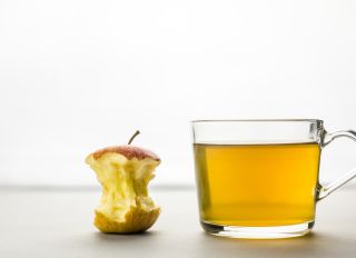 Close-Up Of Drink And Apple Core Against White Background