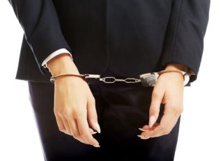Midsection Of Businesswoman With Hand Cuffs Standing Against White Background