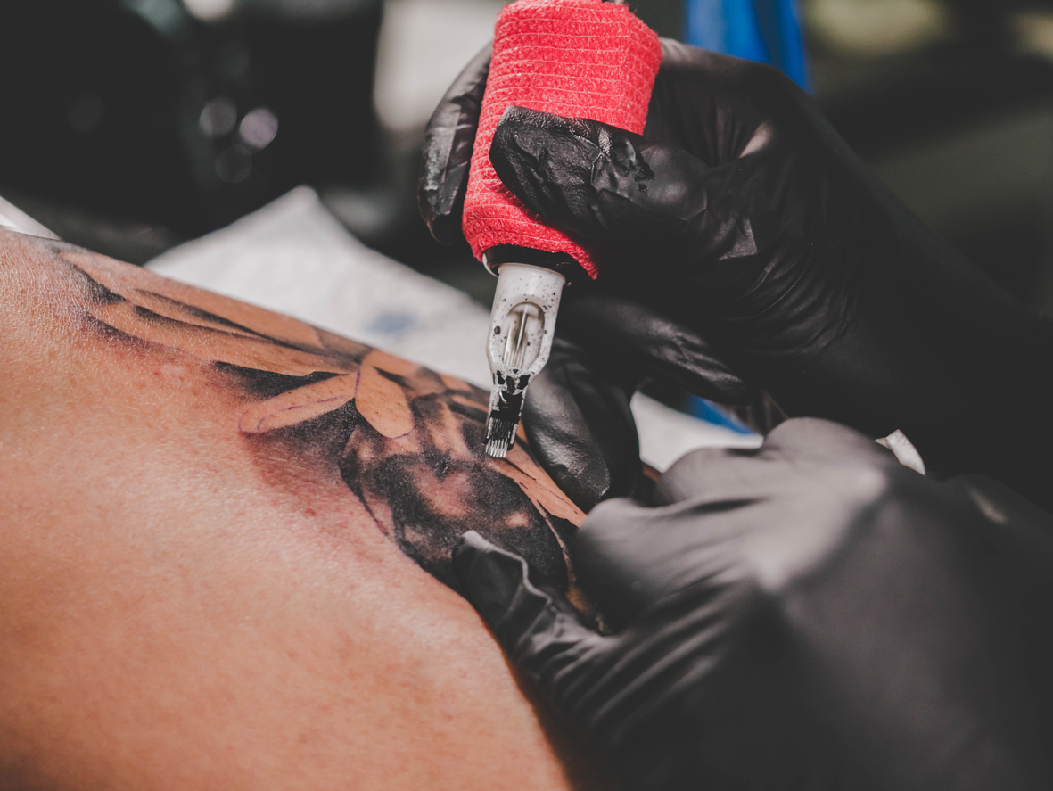 12.11.2011 Varsavia, Polonia. Donna tattoo artist rende un tatto all uomo  del braccio durante il primo giorno del tatuaggio, la verniciatura della  scocca e pierceing show - 'arte del corpo convenzione