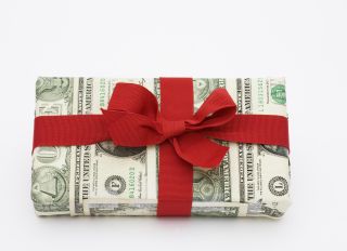 A gift wrapped in dollar bills