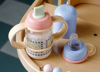 Baby bottle full of milk on a high chair