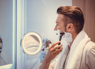 Side View Of Mature Man Shaving At Home