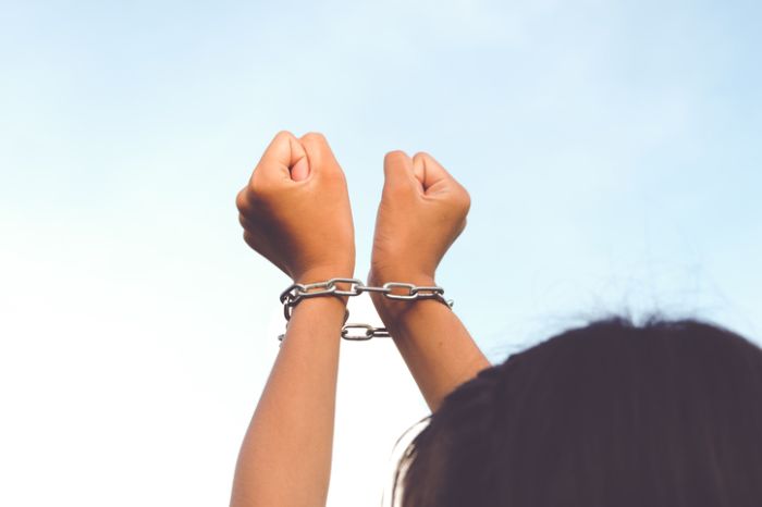 Low Angle View Of Woman Hands With Chain Against Clear Sky