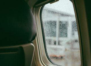 Close-Up Of Vehicle Seat By Wet Window In Airplane
