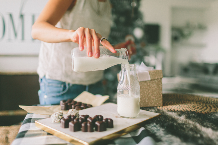 Midsection Of Women Pouring Milk