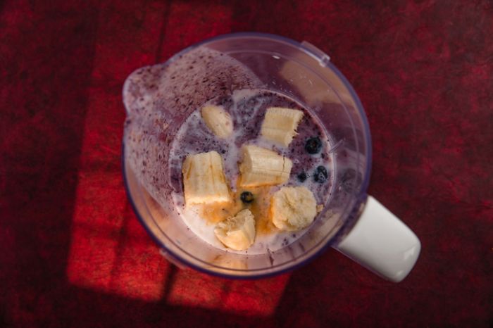 Blueberry smoothie ingredients in countertop blender