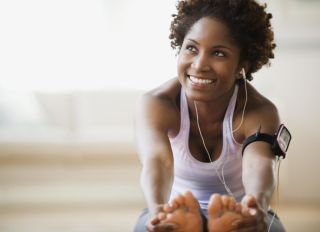 Black woman stretching and listening to mp3 player