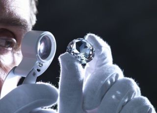 Jeweller inspecting replica diamonds with loupe