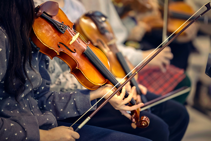Close-up of hands holding violins