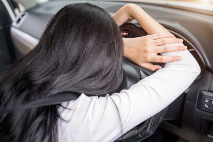 woman sleepy driving in car