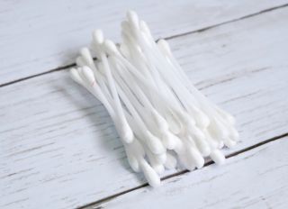 High Angle View Of Cotton Swabs On Wooden Table