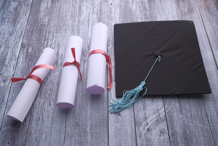 graduation hat and certificate on table