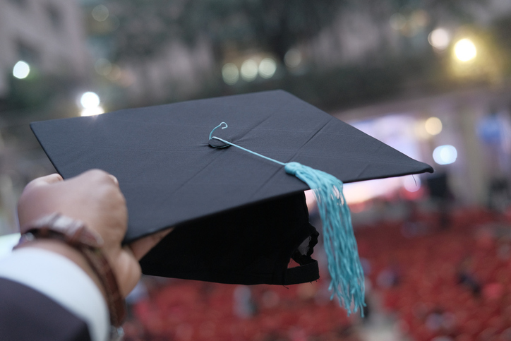 Man hand holding graduation hat