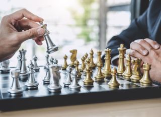 Close-Up Of Business Colleagues Playing Chess In Office