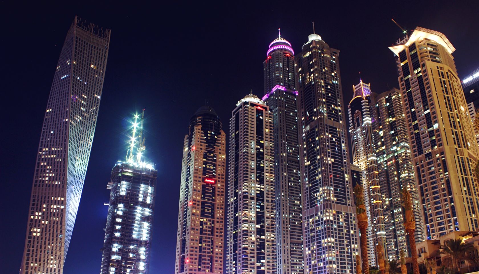 Low Angle View Of Illuminated Modern Skyscrapers At Dubai Marina During Night