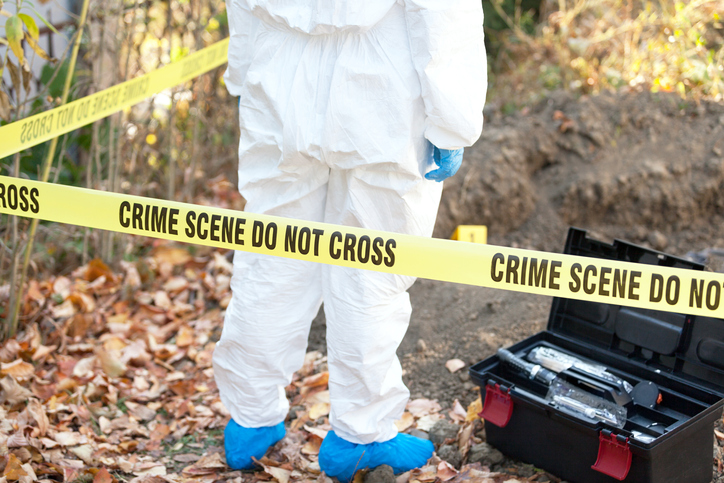 Low Section Of Person Wearing Protective Workwear While Standing At Crime Scene