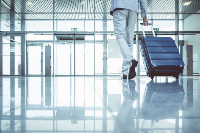 Businessman walking with luggage in airport