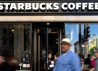 Pedestrians walk by the Hollywood Starbucks Coffee shop in...