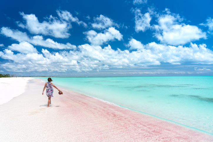 Woman walking through shallow crystal water, Caribbean