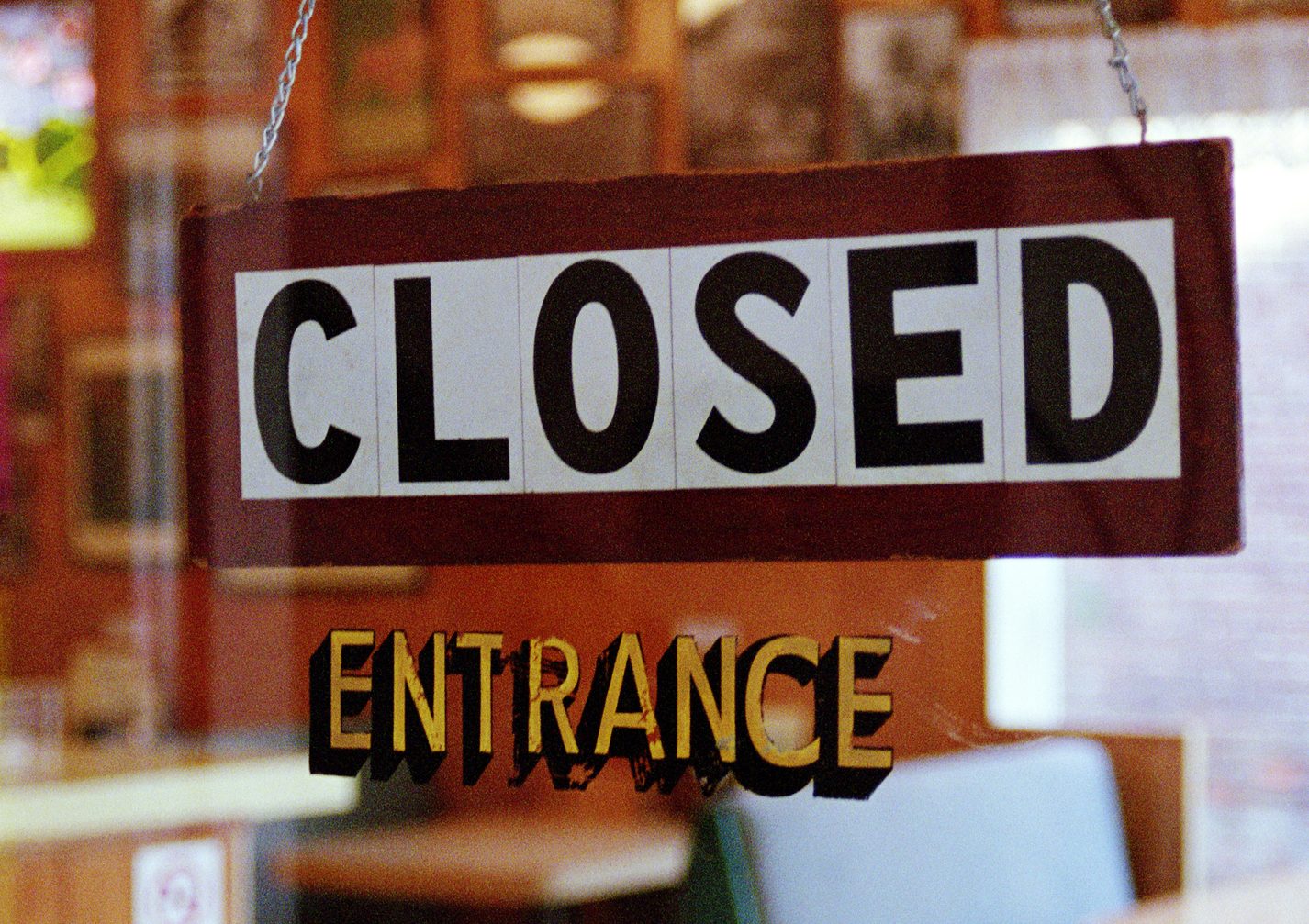 'Closed' sign hanging in eating establishment's doorway