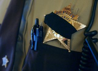 Joey McLeister/Star Tribune St. Paul,Mn.,Sat.,May 7, 2005--Ramsey County Deputy Sheriff Moon Chong wore a black band over his badge in memory of slain St. Paul Police Sergeant Gerald Vick. Chong stood guard at City Hall at a memorial for Vick at the bas