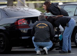 Orange County forensic investigators look for finger prints on a Dodge Stratus belonging to missing