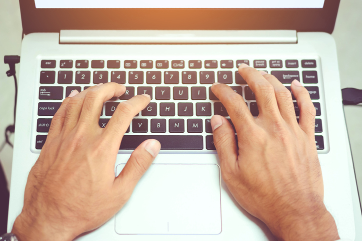 Cropped Hands Of Man Using Laptop