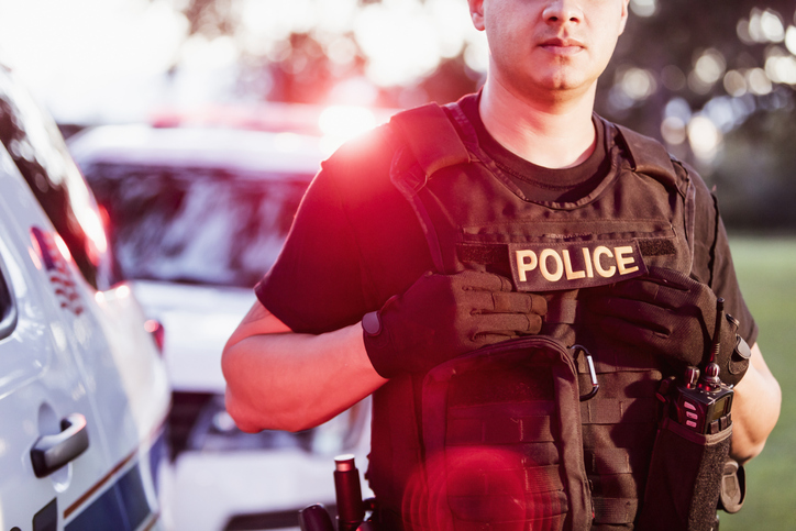 Hispanic police officer wearing bulletproof vest