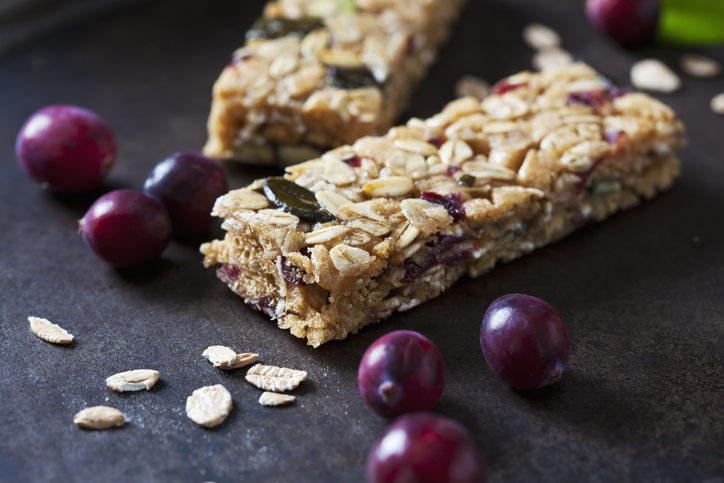 Muesli bars with cranberries and oat flakes on dark background