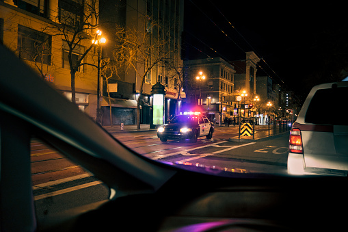 Police car with emergency lights on in downtown district