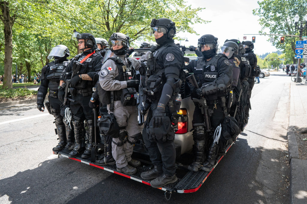 Police clad in riot gear wait to be called into action...