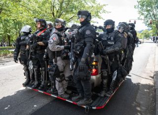 Police clad in riot gear wait to be called into action...