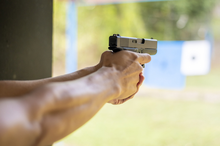 Cropped Hands Of Man Aiming Gun