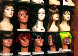 Rows of female mannequin heads wearing wigs - stock photo