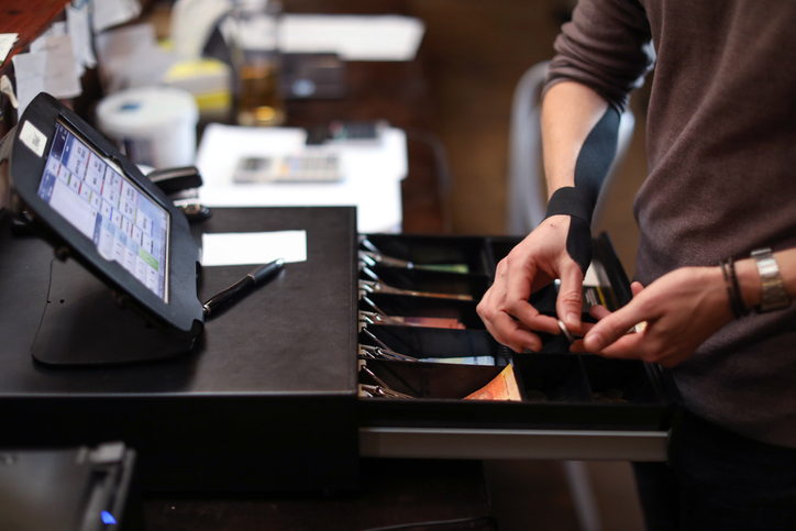 a Restaurant manager using the cash register.