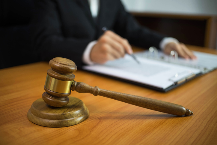 Midsection Of Lawyer With Gavel On Table In Office